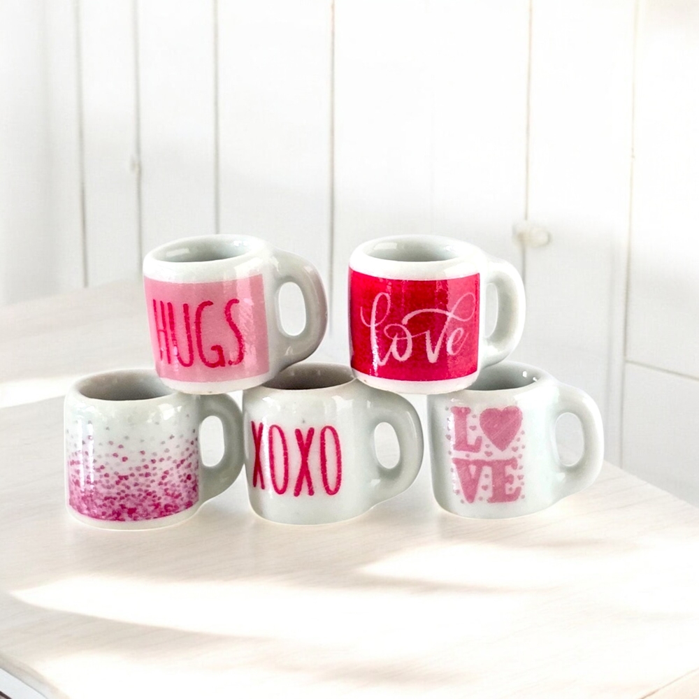 Set of five miniature ceramic mugs with Valentine's designs, featuring 