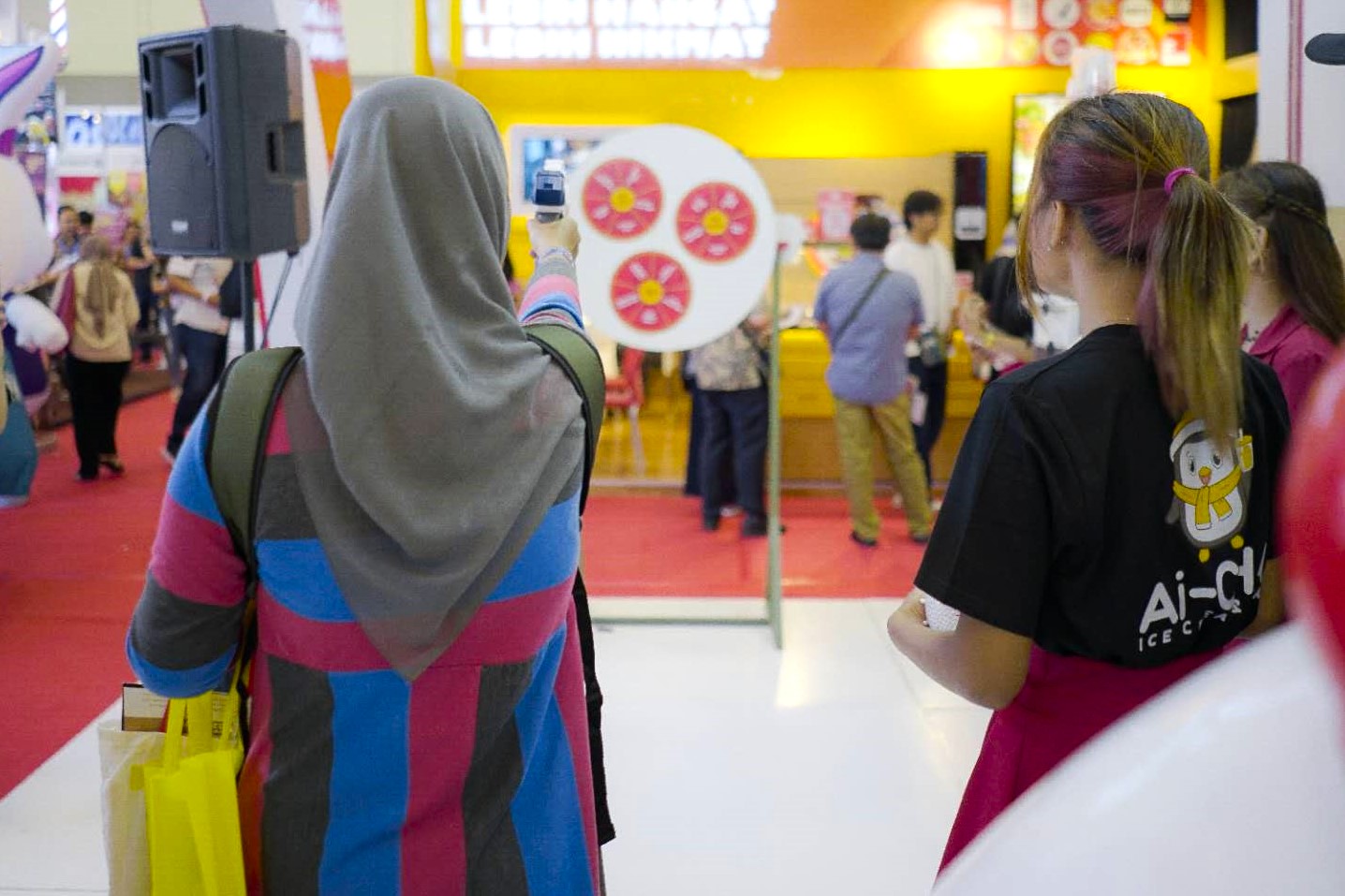 seorang perempuan sedang bermain dart board game di pameran franchise Ai-KA, Ai-CHA, dan ZHENGDA di IFBC 2024