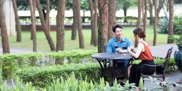 คู่รักดื่มไวน์ในสวนที่ Club Med Guilin
