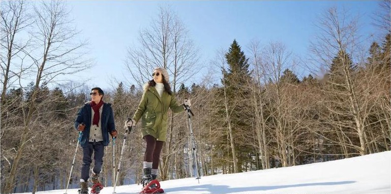 คู่รักเดินสโนว์ชูท่ามกลางป่าหิมะ Club Med Tomamu ฮอกไกโด