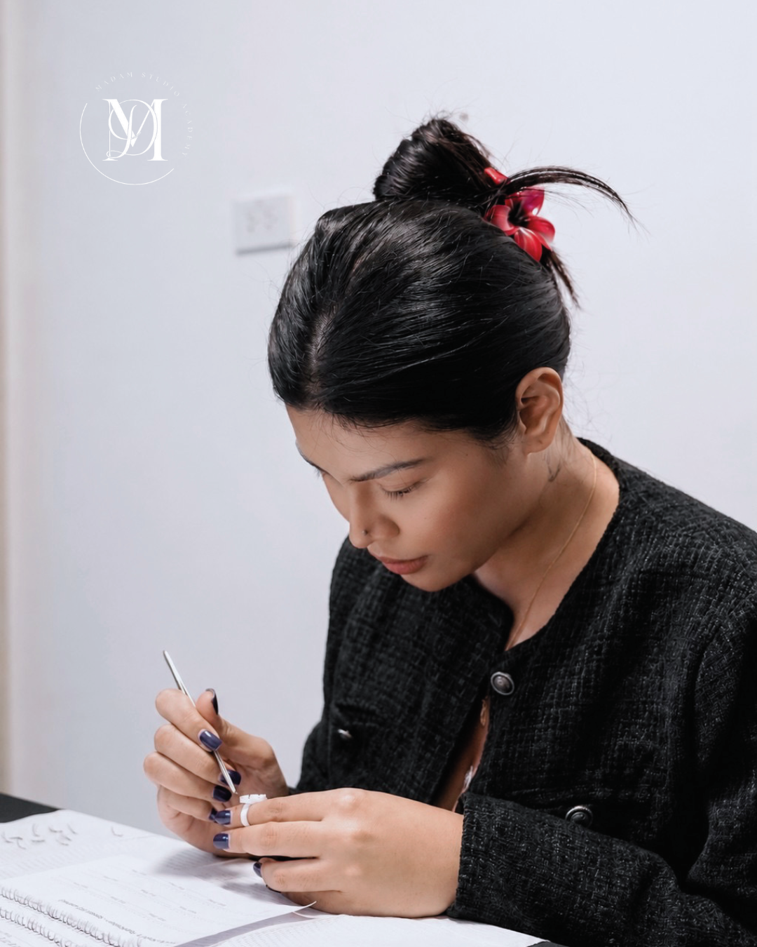 Instructor providing one-on-one eyelash extension training at Madam Studio Academy.