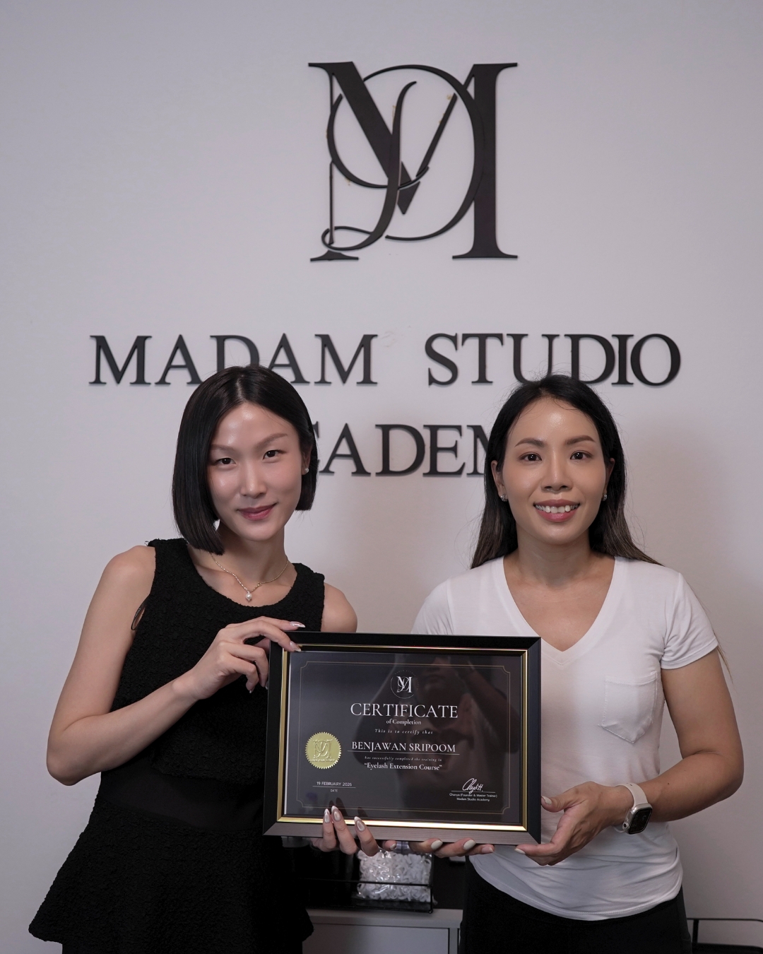 Student receiving a certificate after completing the Eyelash Extension Course at Madam Studio Academy.