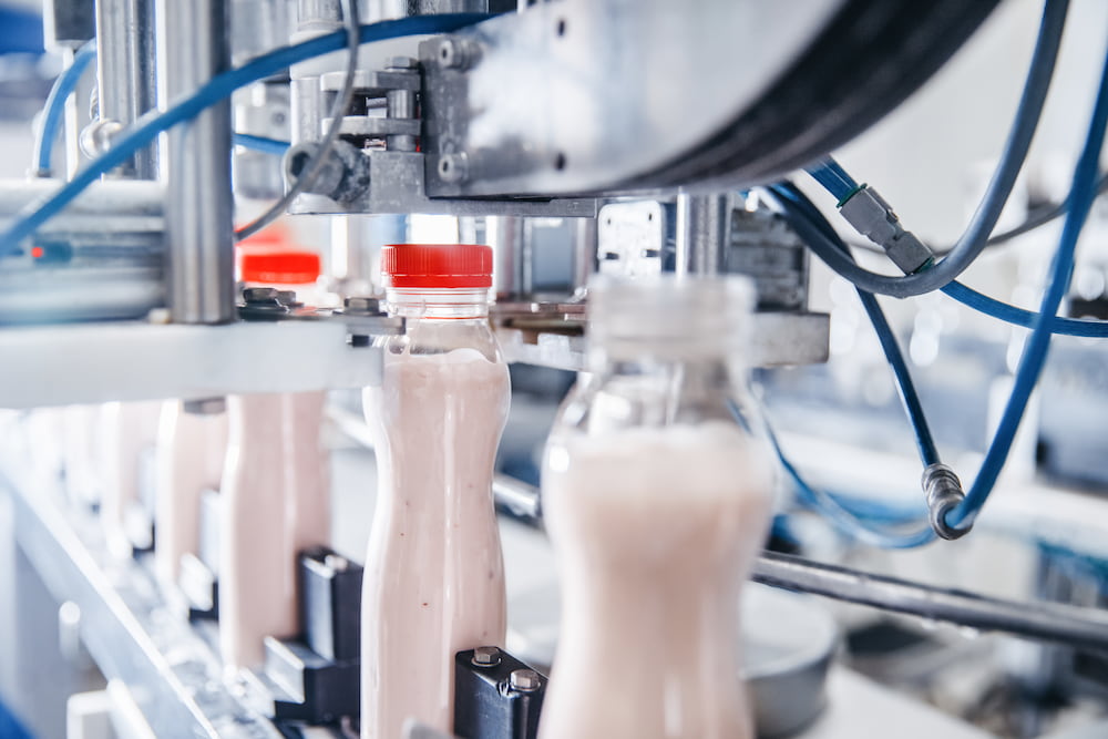 A screw capping machine capping yogurt bottles