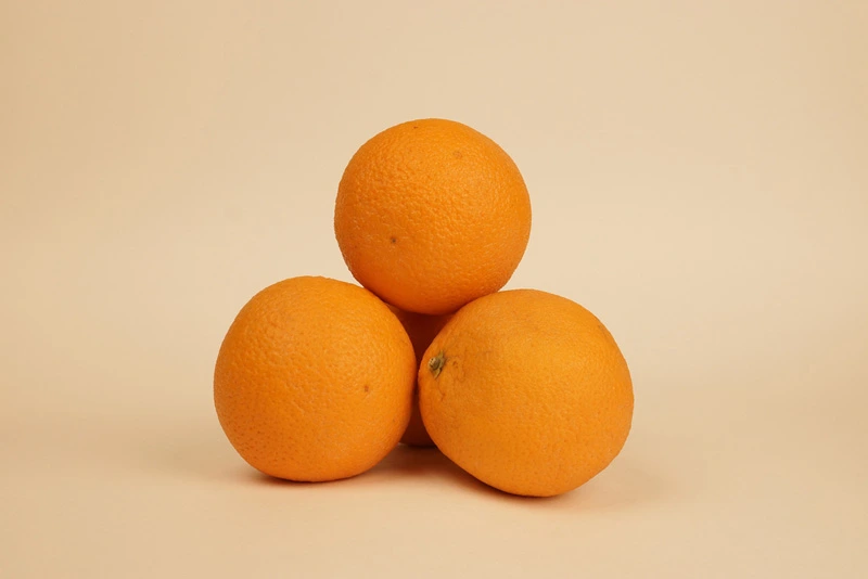 ภาพตัวอย่างการจัดวางส้มมงคล 4 ลูกทรงพีระมิด โดยมีฐาน 3 ลูกและวางยอดทับ 1 ลูก เพื่อความสวยงามและเป็นสิริมงคลตามหลักฮวงจุ้ยในการจัดโต๊ะไหว้เช็งเม้ง