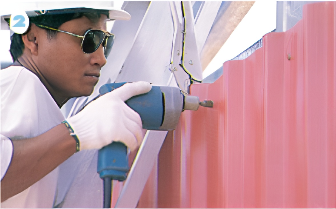 ขั้นตอนที่ 2 เมื่อติดตั้งแผ่นผนังแผ่นแรกเรียบร้อยแล้ว นำแผ่นที่ 2 วางซ้อนทับโดยใช้คีมหนีบหัวและท้าย พร้อมกับยึดสกรูบริเวณแปปลาย, แปเดี่ยวทุกๆ ท้องลอนและแปกลางยึดลอนเว้นลอน ขั้นตอนที่ 2 เมื่อติดตั้งแผ่นผนังแผ่นแรกเรียบร้อยแล้ว นำแผ่นที่ 2 วางซ้อนทับโดยใช้คีมหนีบหัวและท้าย พร้อมกับยึดสกรูบริเวณแปปลาย, แปเดี่ยวทุกๆ ท้องลอนและแปกลางยึดลอนเว้นลอน