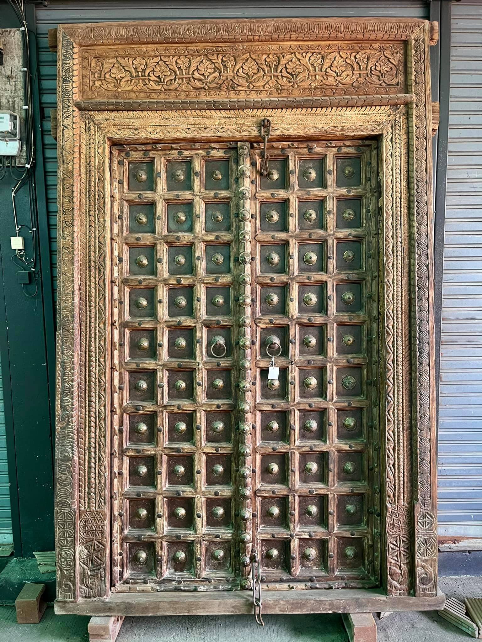 ประตูไม้เก่าโบราณบานใหญ่แต่งทองเหลืองเต็มบาน
