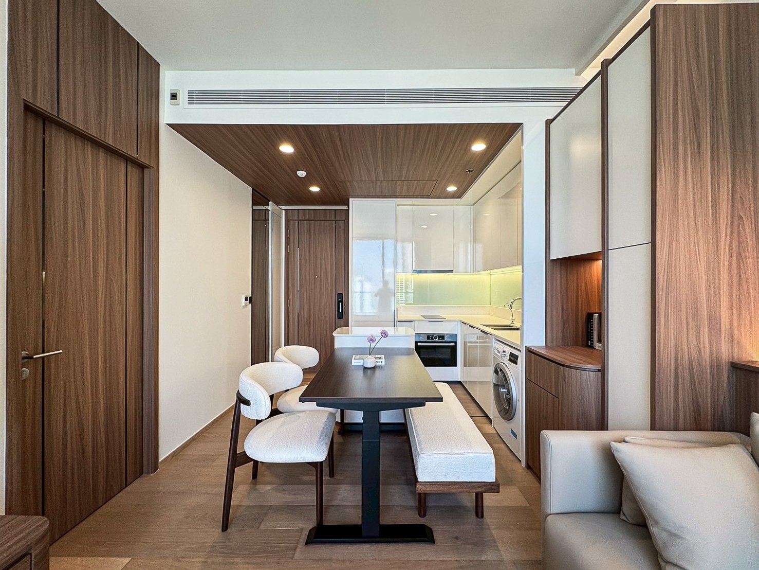 Dining table, chairs and bench between the kitchen and sofa at Anil Sathorn