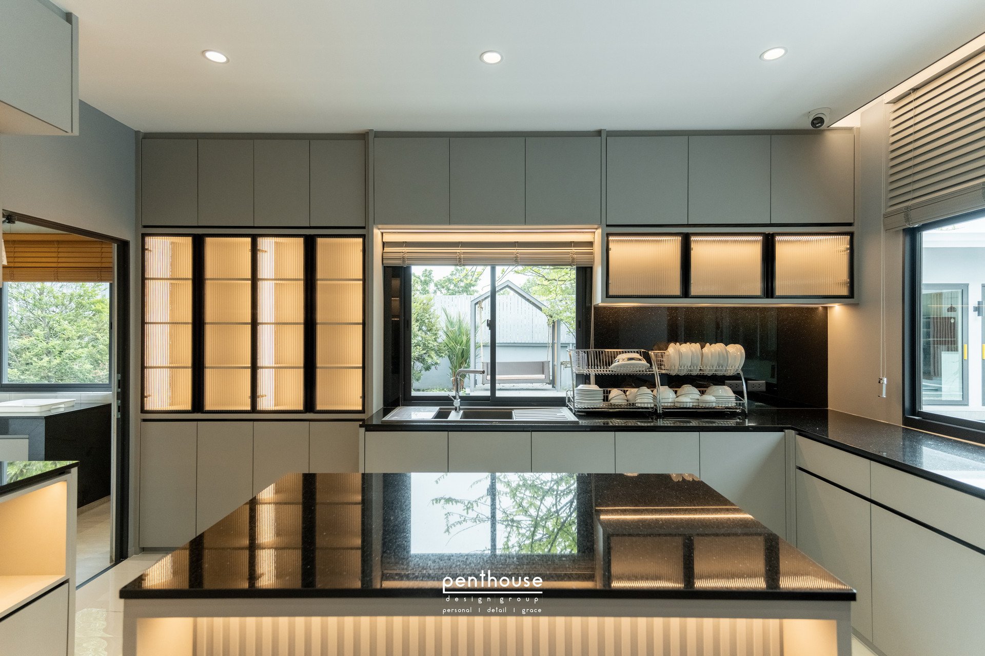 Completed Theera House kitchen with under-cabinet counter lighting, illuminated glass cabinets and ceiling downlights