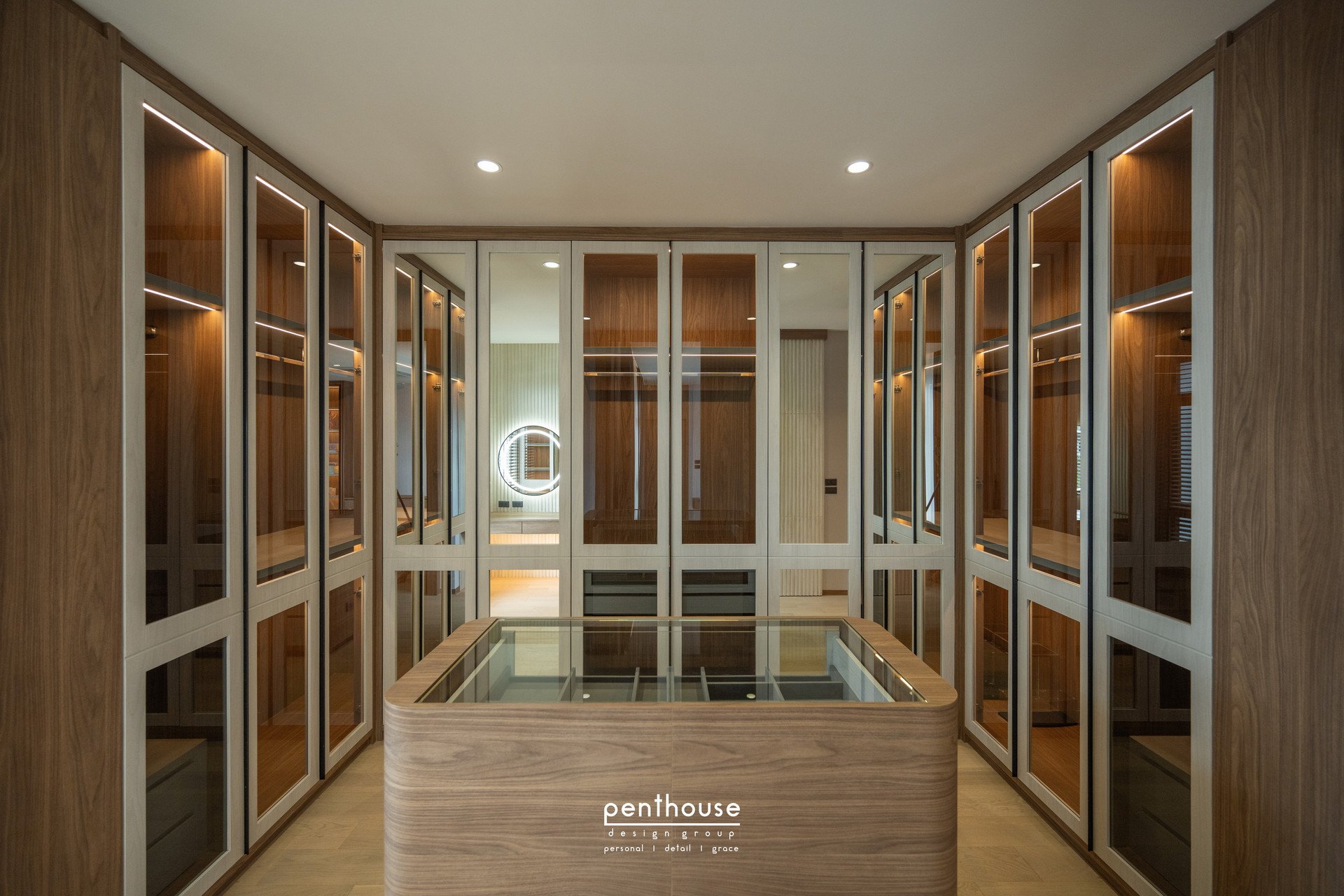 Completed Theera House dressing room with light lines inside glass-fronted wardrobes and a central island