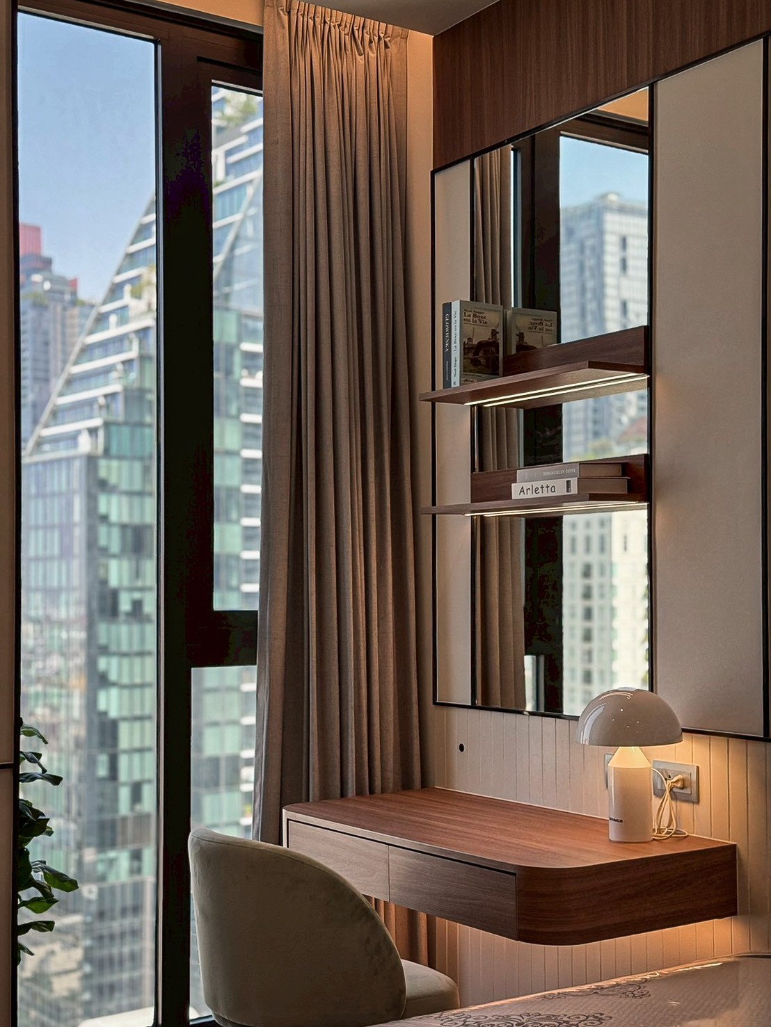 Completed Anil Sathorn 12 window-side desk with overhead shelving and a curtain beside the work surface