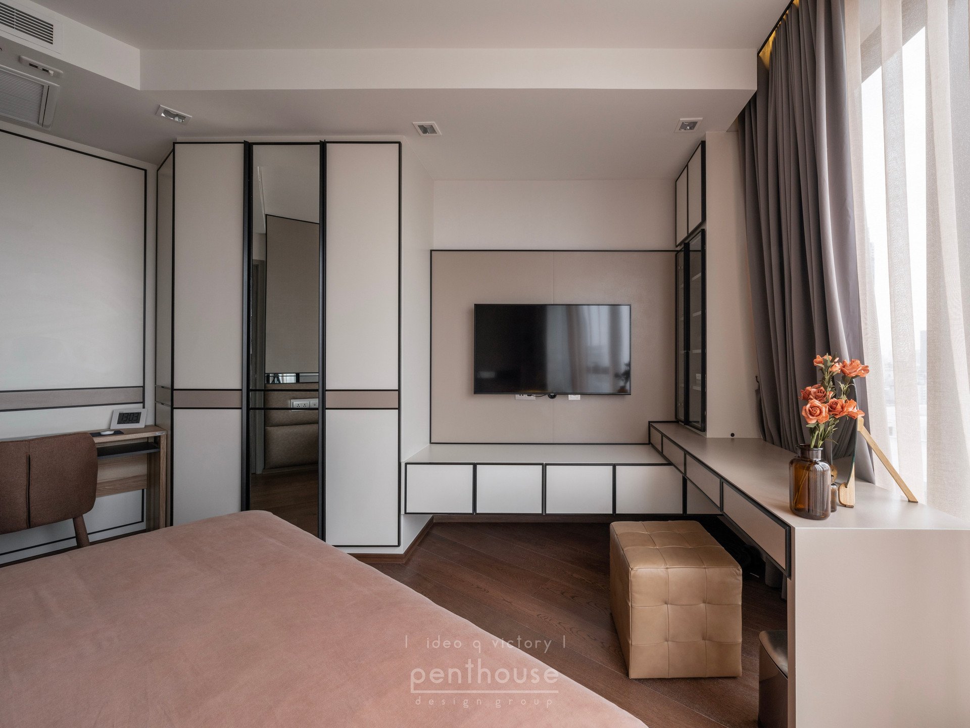 Completed Ideo Q Victory bedroom showing a bed, television cabinetry and window-side table in one view