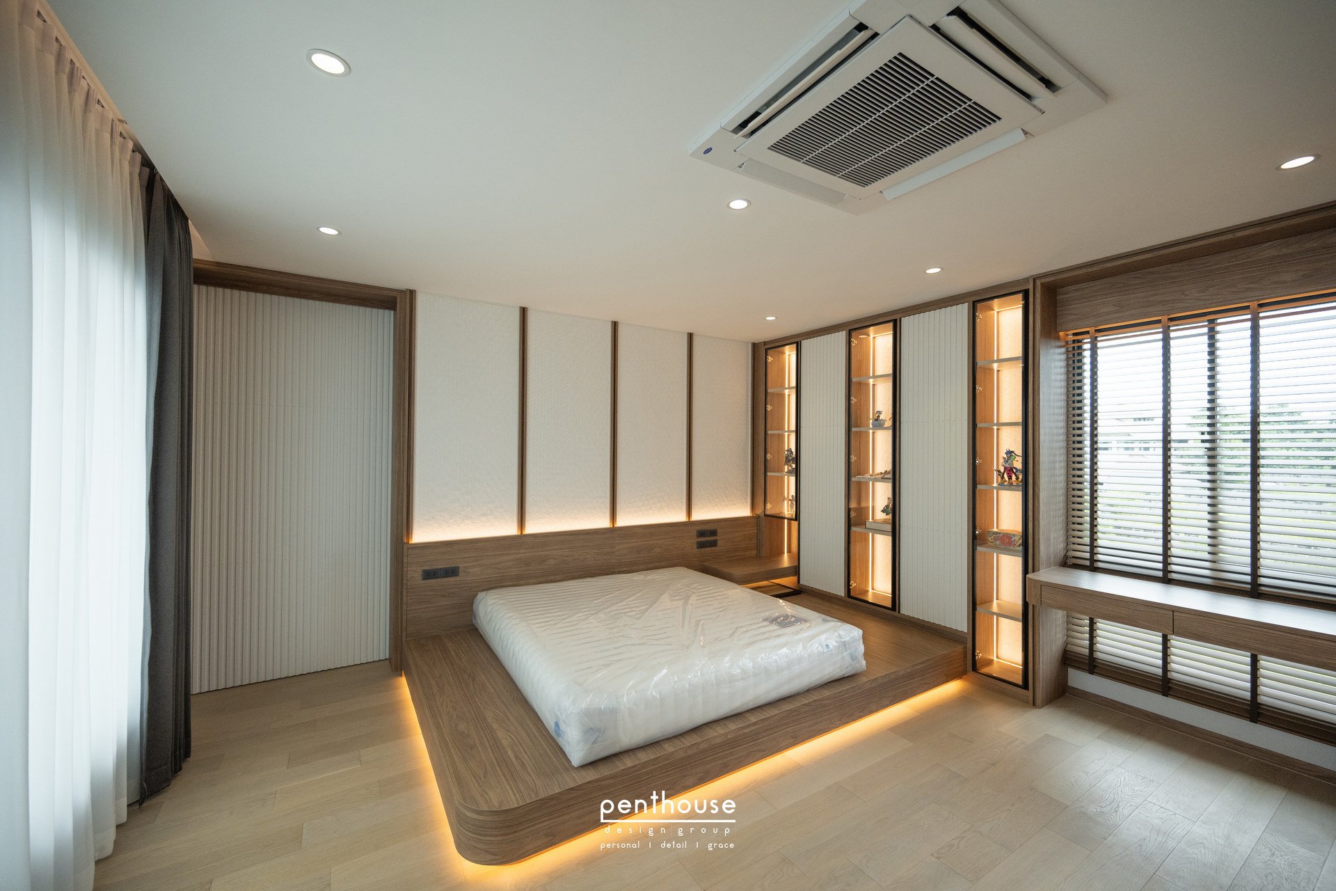 Real Theera House bedroom with a raised bed platform, display shelving and a window-side desk