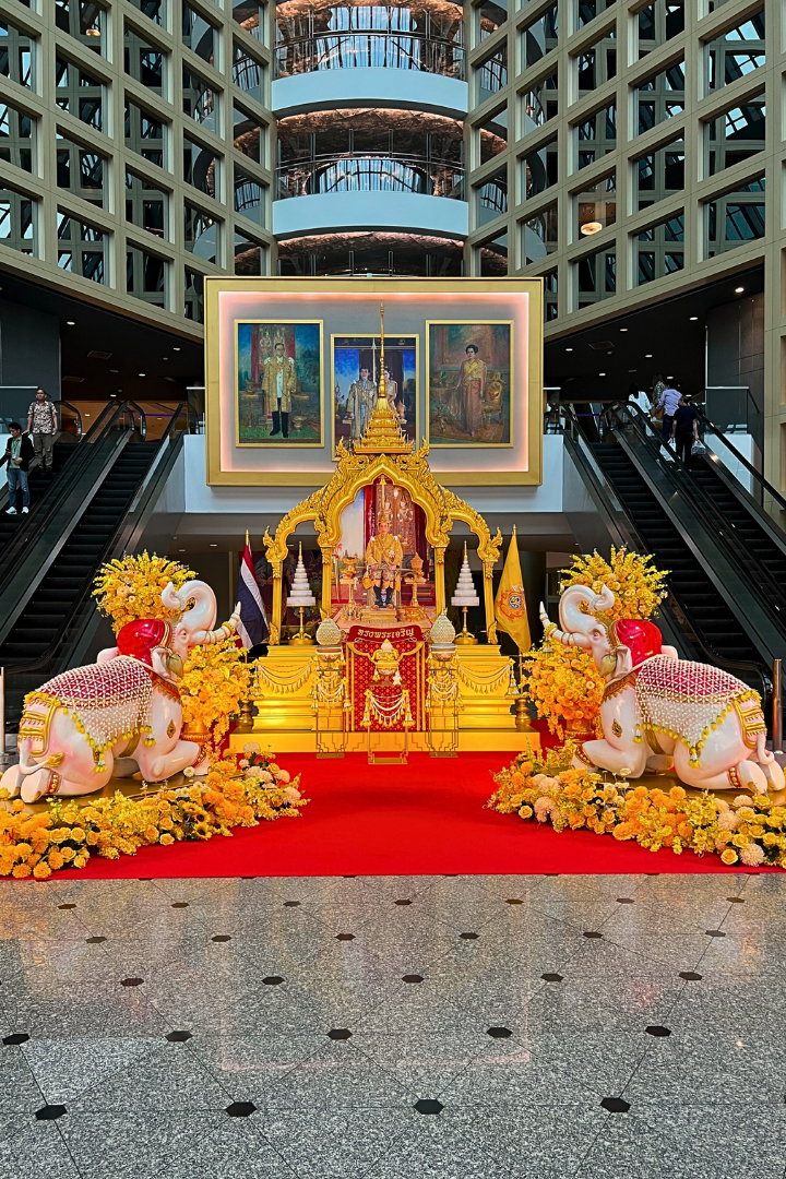 ซุ้มเฉลิมพระเกียรติสีทองสง่างามพร้อมดอกไม้สีเหลืองอร่าม ณ สถานที่จัดงาน จัดทำโดยผู้รับเหมาจัดซุ้มพิธีการ ช่างดอกไม้งานเฉลิมพระเกียรติ และบริการจัดดอกไม้งานพิธีการนอกสถานที่ สำหรับงานราชการและงานถวายความเคารพ