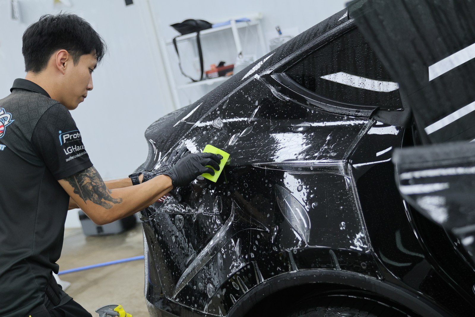 ช่างรีดฟิล์มบนประตูหลังรถ Tesla สีดำ