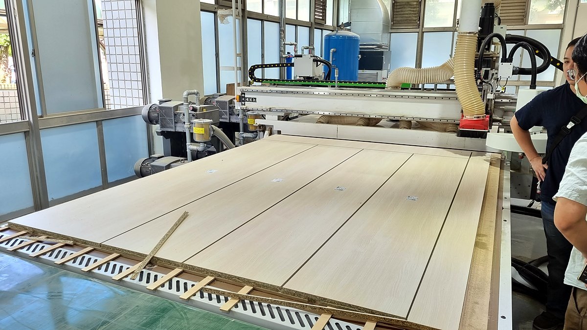 CNC machine cutting and drilling panels at a built-in furniture factory