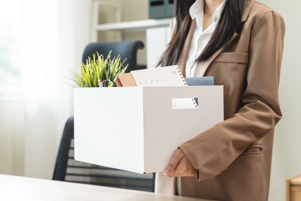 ผู้หญิงเก็บของจากโต๊ะทำงานหลังโดนเลย์ออฟจากบริษัท