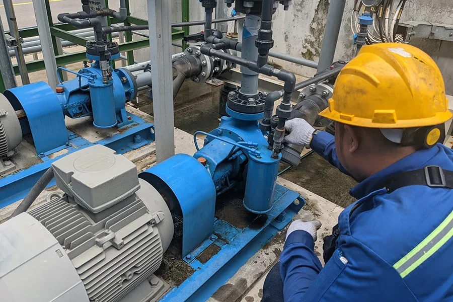 ช่างกำลังตรวจสอบเกียร์มอเตอร์ในระบบเครื่องจักรอุตสาหกรรม