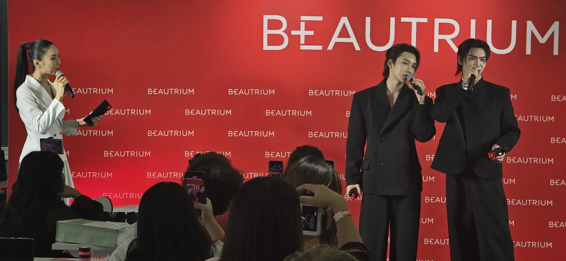 ช่วงสนทนาบนเวที มีแบ็กดรอป BEAUTRIUM สีแดง