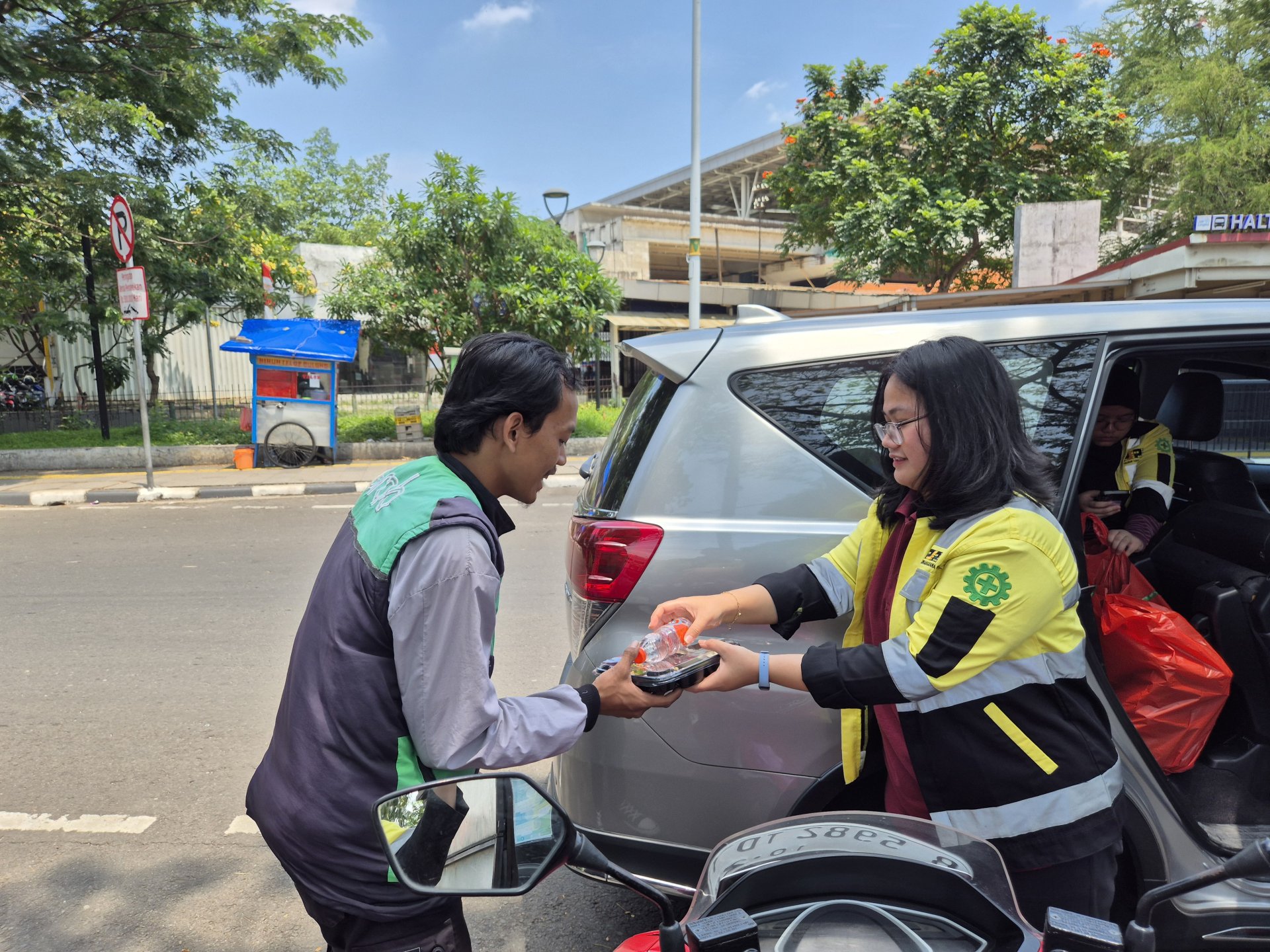 Tim PT Pembangunan Sarana Perkasa memberikan kotak nasi Jumat Berkah kepada pengemudi ojek online di area Manggarai, Jakarta pada 12 September 2025.