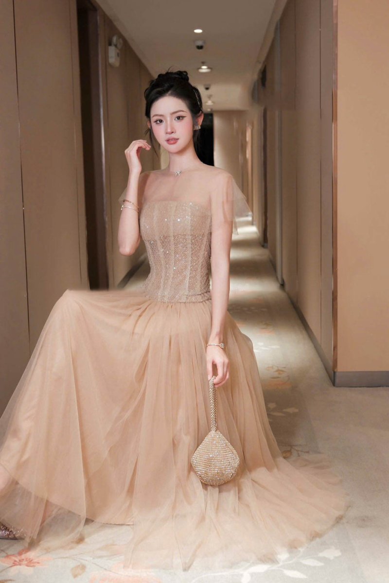 เดรสยาวสีเบจมีตกแต่งลูกปัดแวววาวมีผ้าซีทรูคลุมไหล่หรูหรา