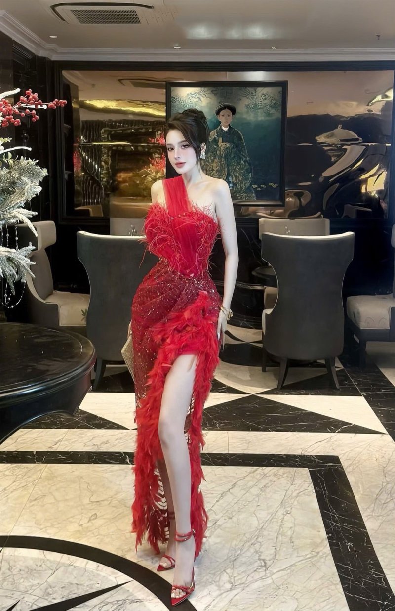 เดรสยาวสีแดงปาดไหล่ผ่าข้างตกแต่งขนนกและคริสตัล
