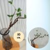 กิ่งไม้ใบไม้ปลอมประดิษฐ์แจกันแก้ว Artificial branches and leaves in a glass vase.