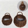 ตะกร้าสานแขวนผนังต้นไม้ปลอมใส่ของใช้ของตกแต่ง Woven wall-mounted basket for holding decorative items and supplies.