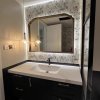 A wall-mounted vintage-style bathroom mirror, designed for makeup and everyday grooming. Showcasing a luxurious French aesthetic, this large mirror is perfect for placement above the sink and comes equipped with intelligent features, including an anti-fog
