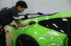 ช่างวางฟิล์มใสบนตัวถังด้านข้างรถ Porsche สีเขียว ช่างวางฟิล์มใสบนตัวถังด้านข้างรถ Porsche สีเขียว
