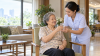 Thai nurse offering water to an older adult safely Thai nurse offering water to an older adult safely