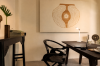 A writing desk and chair beneath a framed artwork