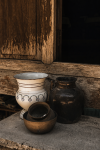 Old earthenware jars against a weathered timber wall