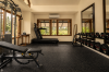 The gym with weights, bench and treadmill, windows opening to the garden