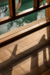Late light and the shadow of a window frame across the timber floor