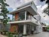 Modern three-storey building with large windows and glass balcony railings