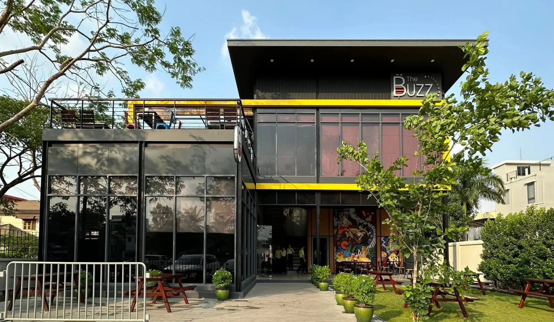 Front view of a two-storey building with yellow trim and a landscaped garden Front view of a two-storey building with yellow trim and a landscaped garden
