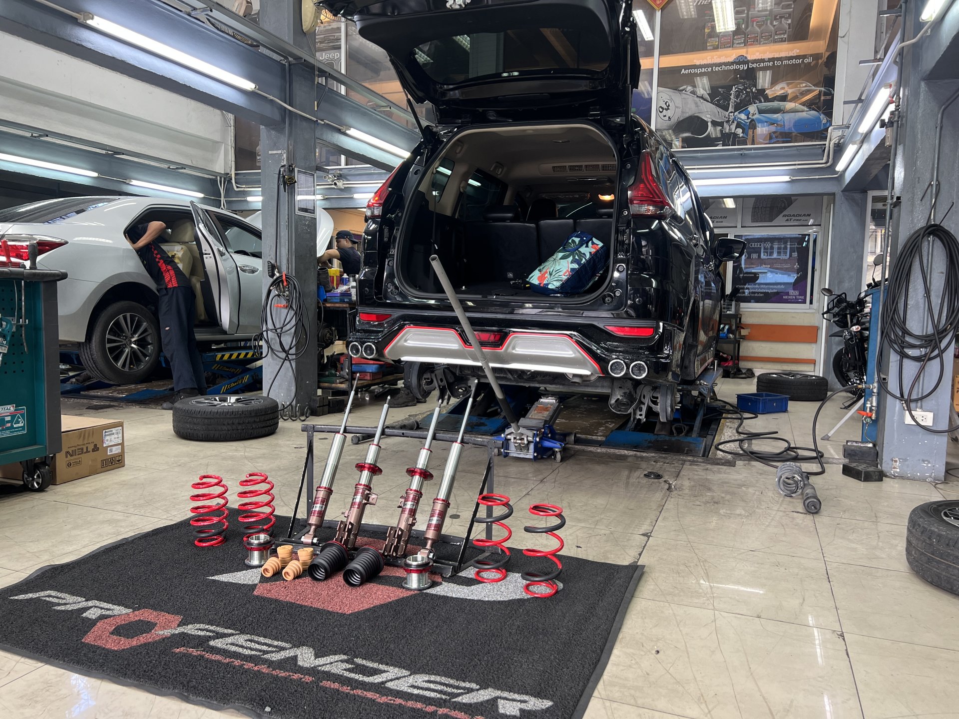 งานติดตั้งโช้คอัพ Profender Drift Series ในรถ Mitsubishi Xpander แสดงให้เห็นชุดโช้คสไลด์กระบอกสีแดงที่เป็นเอกลักษณ์และการปรับเซตความสูงที่ลงตัว งานติดตั้งโช้คอัพ Profender Drift Series ในรถ Mitsubishi Xpander แสดงให้เห็นชุดโช้คสไลด์กระบอกสีแดงที่เป็นเอกลักษณ์และการปรับเซตความสูงที่ลงตัว
