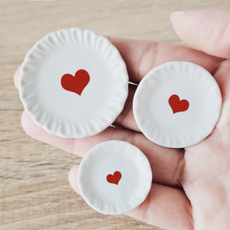 Set of three miniature ceramic plates with red heart designs, sizes 4.5 cm, 3.5 cm, and 2.8 cm, perfect for Valentine's Day dollhouse decor.