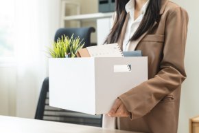 ผู้หญิงเก็บของจากโต๊ะทำงานหลังโดนเลย์ออฟจากบริษัท