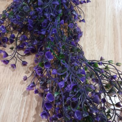 ดอกไม้เลื้อยปลอมดอกไม้ประดิษฐ์ในตะกร้าสานแขวนผนัง Artificial climbing flowers in a woven wall basket.