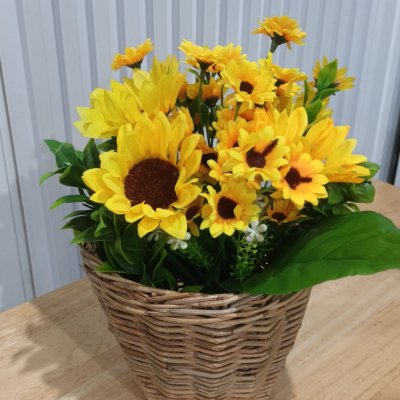 ดอกทานตะวันปลอมดอกไม้ประดิษฐ์สีเหลืองในตะกร้าหวาย Artificial yellow sunflower in a wicker basket.