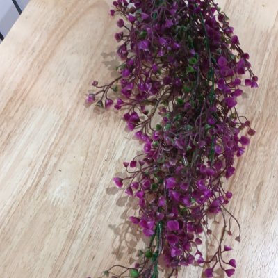 ดอกไม้เลื้อยปลอมดอกไม้ประดิษฐ์ในตะกร้าสานแขวนผนัง Artificial climbing flowers in a woven wall basket.