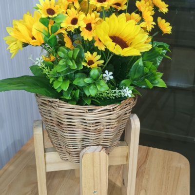 ดอกทานตะวันปลอมดอกไม้ประดิษฐ์สีเหลืองในตะกร้าหวาย Artificial yellow sunflower in a wicker basket.