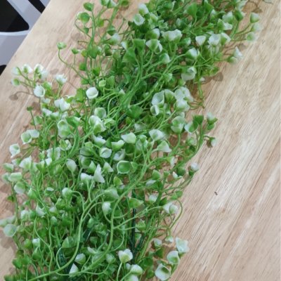 ดอกไม้เลื้อยปลอมดอกไม้ประดิษฐ์ในตะกร้าสานแขวนผนัง Artificial climbing flowers in a woven wall basket.