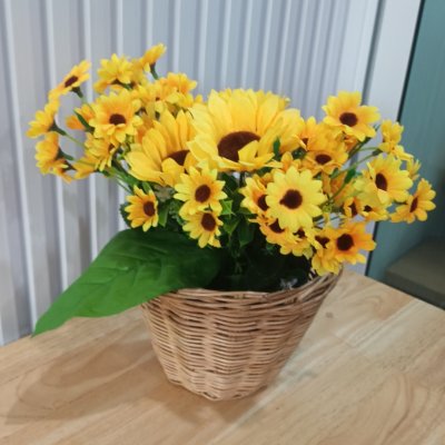 ดอกทานตะวันปลอมดอกไม้ประดิษฐ์สีเหลืองในตะกร้าหวาย Artificial yellow sunflower in a wicker basket.
