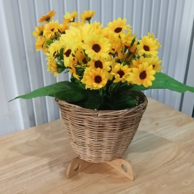 ดอกทานตะวันปลอมดอกไม้ประดิษฐ์สีเหลืองในตะกร้าหวาย Artificial yellow sunflower in a wicker basket.