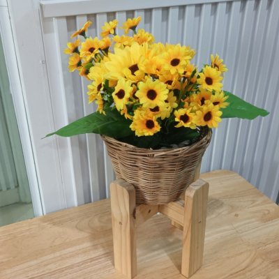 ดอกทานตะวันปลอมดอกไม้ประดิษฐ์สีเหลืองในตะกร้าหวาย Artificial yellow sunflower in a wicker basket.