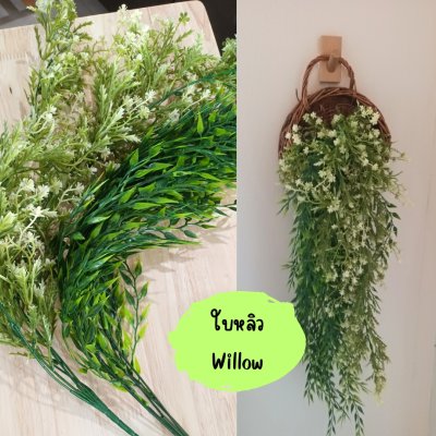 ดอกไม้เลื้อยปลอมสีขาวในตะกร้าสานแขวนผนัง Artificial white climbing flowers in a woven basket.