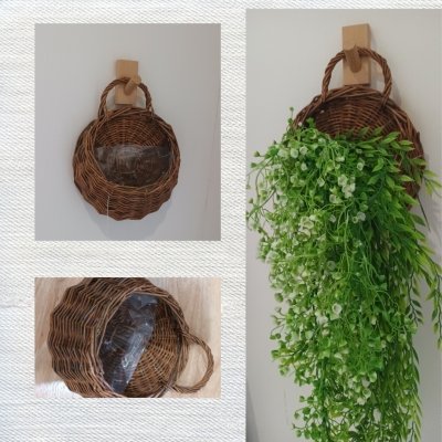 ตะกร้าสานแขวนผนังต้นไม้ปลอมใส่ของใช้ของตกแต่ง Woven wall-mounted basket for holding decorative items and supplies.