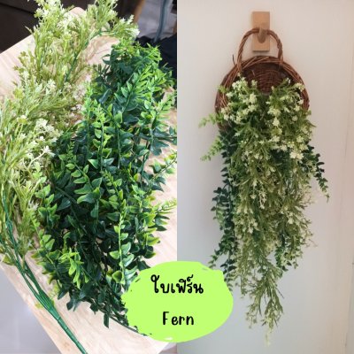 ดอกไม้เลื้อยปลอมสีขาวในตะกร้าสานแขวนผนัง Artificial white climbing flowers in a woven basket.